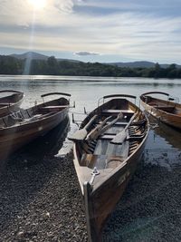 Boats moored on lake against sky