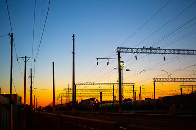 Silhouette electricity pylons against sky during sunset sunset train path city industrial romantic
