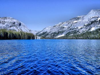 Scenic view of lake and mountains against clear blue sky