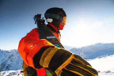 Rear view of man standing on snowcapped mountain