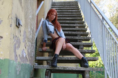Portrait of smiling young woman sitting on steps