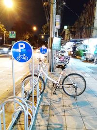 Bicycle parked on street in city at night