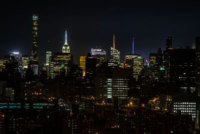 Illuminated cityscape against sky at night