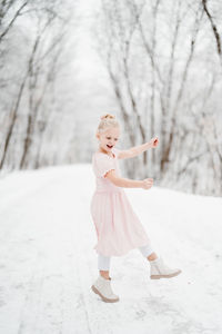 Portrait of girl dancing on snow covered trail