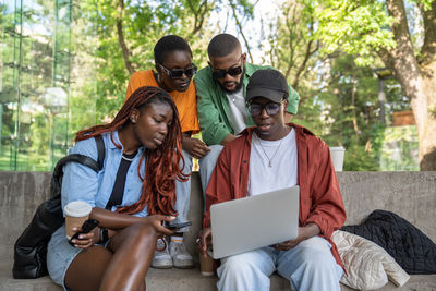 Friends using laptop at park