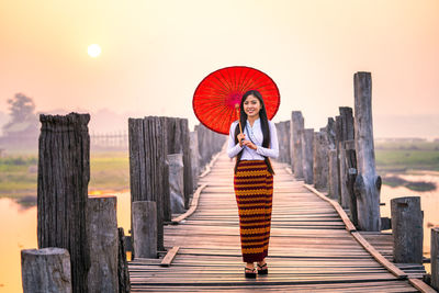 Full length of woman walking on pier against sky