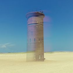 Lifeguard hut on beach against clear blue sky