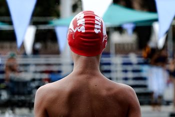 Rear view of shirtless boy wearing swimming cap