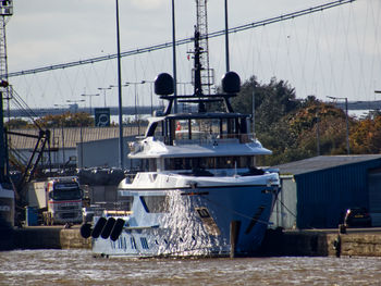 Boats moored at harbor against sky