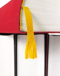 Close-up of yellow tied hanging against wall