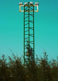 Low angle view of built structure amidst plants against clear blue sky