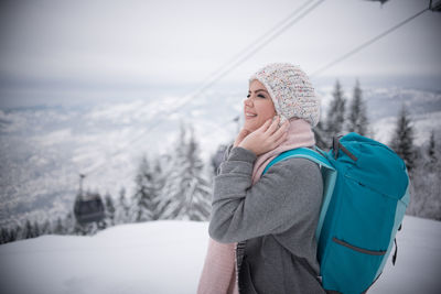 Woman wearing hat standing in snow