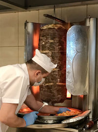 Side view of man working in kitchen