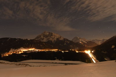 Scenic view of snowcapped mountains against sky at night