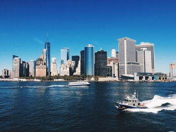 Scenic view of sea and buildings against clear blue sky