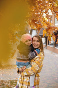 Portrait of smiling young woman standing against sky