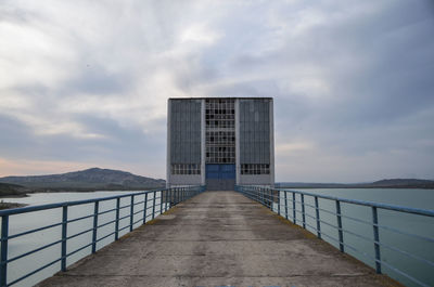 Walkway by building against sky