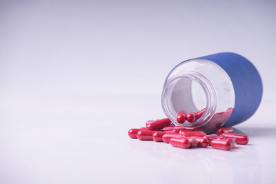Close-up of red light on table against white background