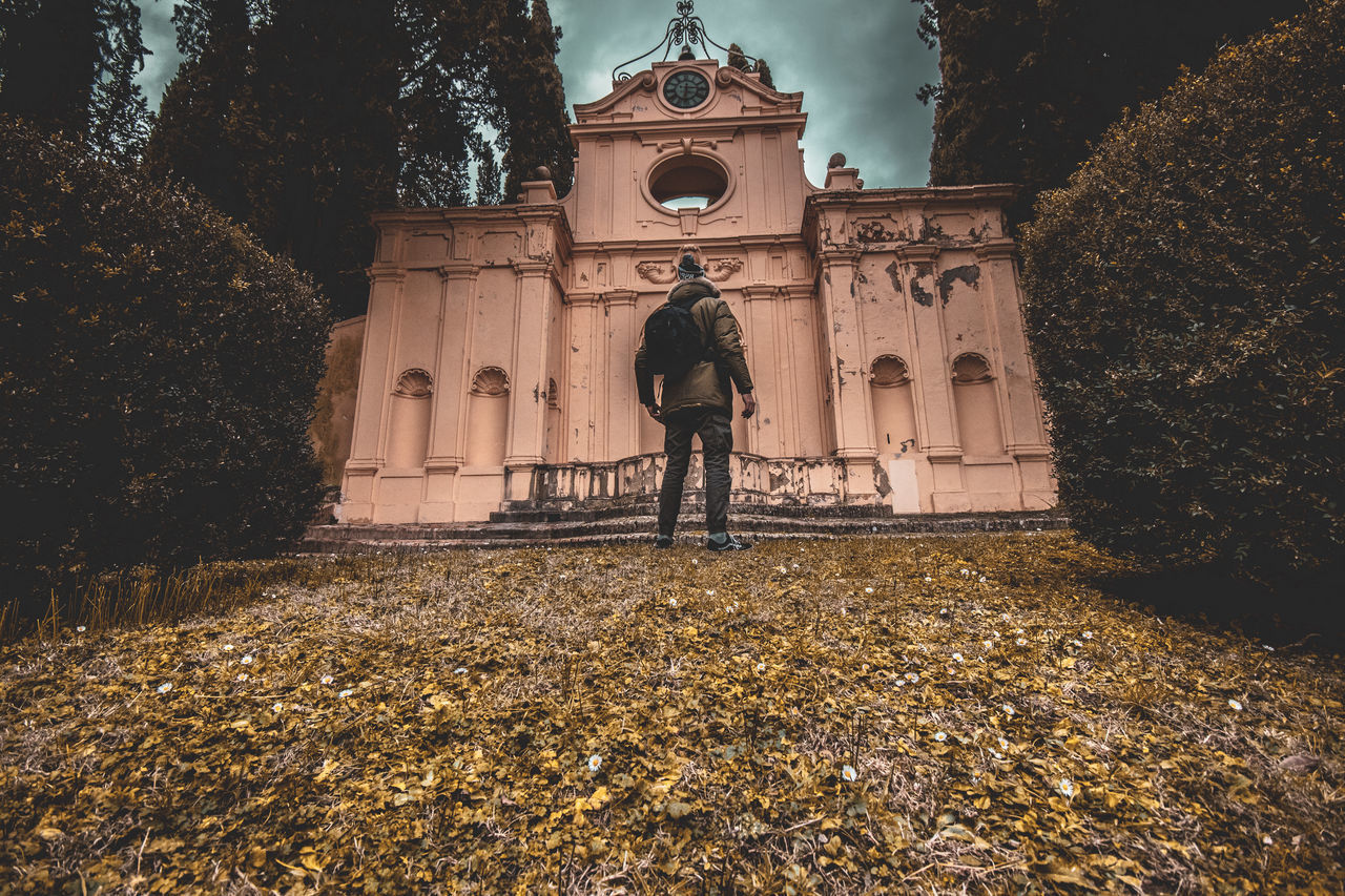 STATUE AGAINST TREES AND BUILDING