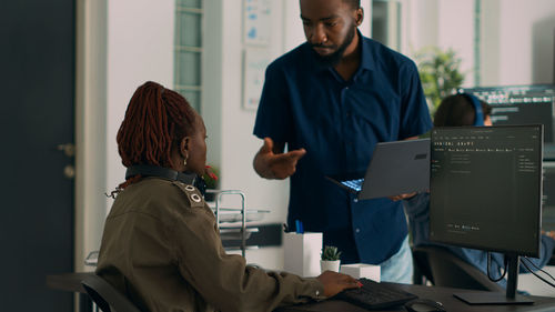 Portrait of man using digital tablet while standing in office