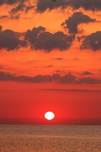 Scenic view of sea against dramatic sky during sunset