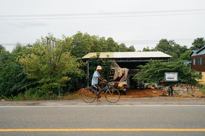 Bicycle by street against sky in city