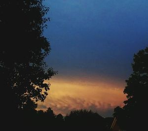 Low angle view of silhouette trees against sky at sunset