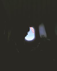 Portrait of woman in illuminated dark room