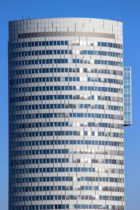 Low angle view of office building against blue sky