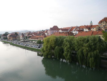 Scenic view of river by buildings against sky