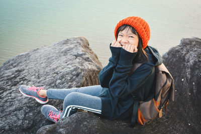 Portrait of girl sitting against lake