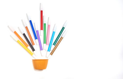 High angle view of multi colored pencils against white background