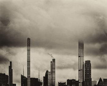 Modern buildings in city against cloudy sky