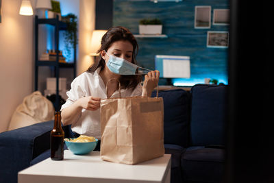 Woman sitting on sofa at home