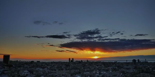 Silhouette cityscape against sky during sunset