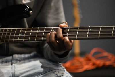 Midsection of man playing guitar