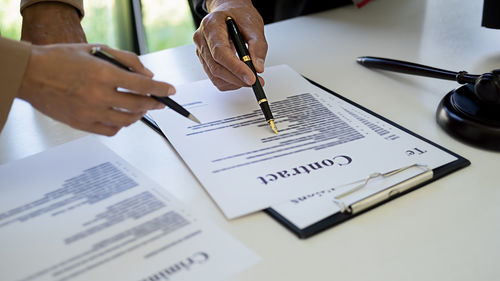 Midsection of person reading book on paper