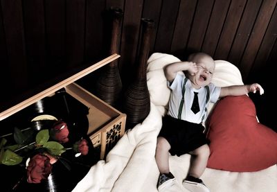 High angle view of cute boy lying on bed