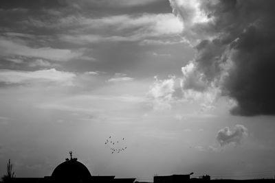 Low angle view of silhouette building against sky