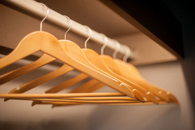 Close-up of wooden coathangers hanging on clothes rack