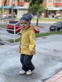 Full length of cute boy standing on footpath