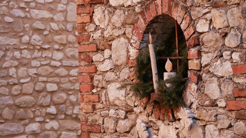 Low section of woman standing against brick wall