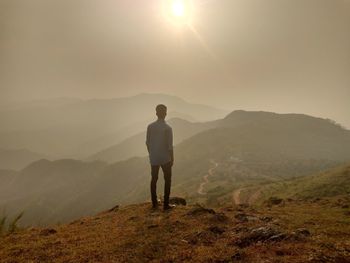 Rear view of man standing on mountain road