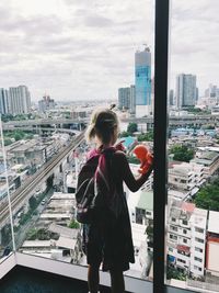 Full length of woman standing against buildings in city