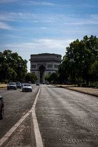 Road by building in city against sky