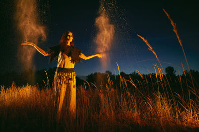 Low angle view of woman standing on field against sky