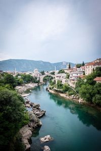 High angle view of river amidst buildings against sky