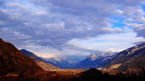 Scenic view of snowcapped mountains against cloudy sky