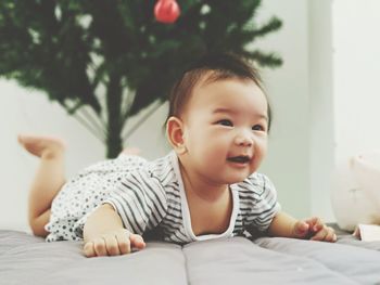 Close-up of cute baby girl relaxing on bed