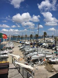Boats moored at harbor against sky